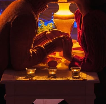 a romantic couple sitting at a table with candles