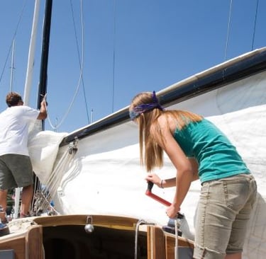 a woman standing on a boat with a man on it