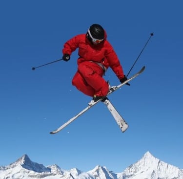 a person in a red jacket and skis in the air