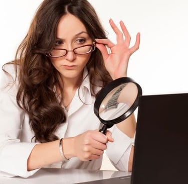 a woman in glasses looking at a laptop computer screen