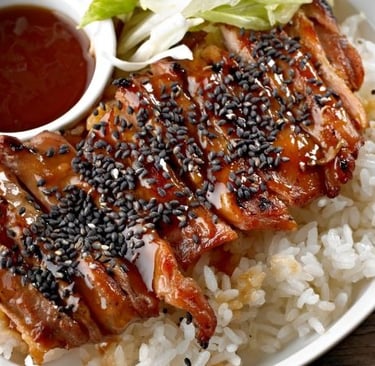 a plate of food with rice, teriyaki and meat
