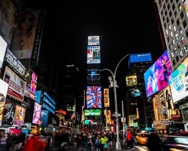 times square new york at night with a lot of people walking around