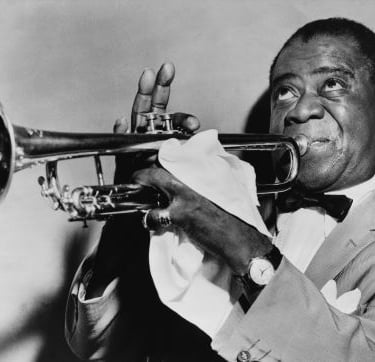 a man in a suit and bow tie playing the trumpet