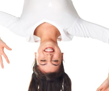 a woman in white shirt and white pants upside down