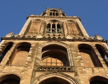 a tall tower in utrecht with a clock on top of it