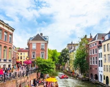 a boat on a canal in utrecht with people on it