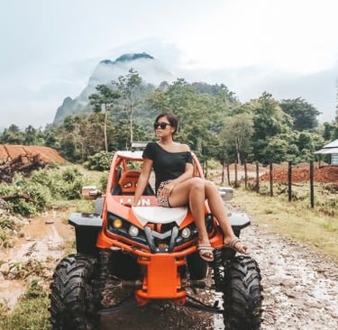 a woman sitting on a atv with a mountain in the background
