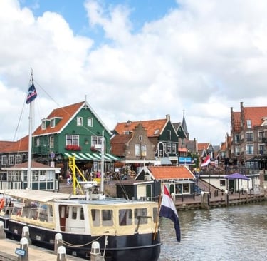Traditional green wooden houses and tourist boat at Volendam harbor in the Netherlands.