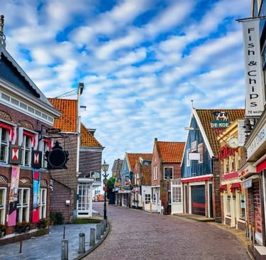 Charming cobblestone street in Volendam, Netherlands, with traditional Dutch architecture and fish and chips shops.