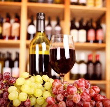 a glass of wine and grapes on a table