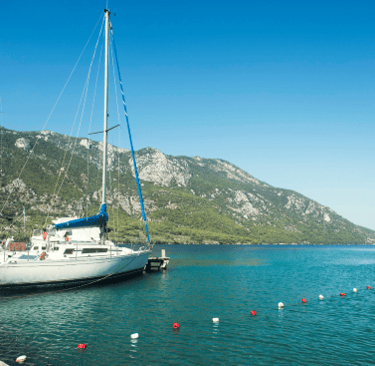 a sailboat in the water near a mountain