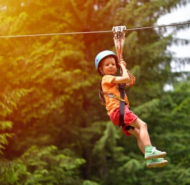 a young boy is zipping through the zip line of a zip line