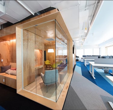 a glass walled office space with a couch and a chair in Dubai