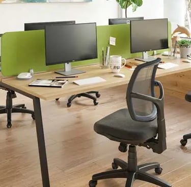 a desk with two computer monitors and a desk with two chairs