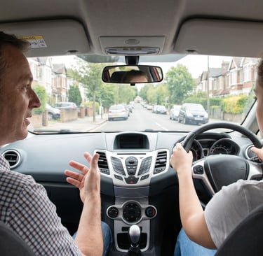 Learner driver during driving lessons in Chingford driving along a busy high street.