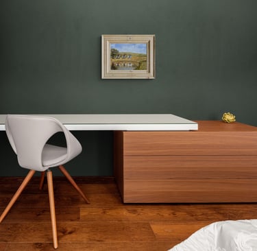 Modern home office featuring a white desk, wood drawers, and a grey swivel chair against a dark green wall.