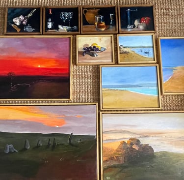 A collection of framed oil paintings featuring landscapes, coastal scenes, and still life art on a textured rug.