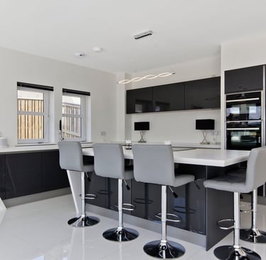 Modern bespoke kitchen with black cabinetry and large central island in East Kilbride.