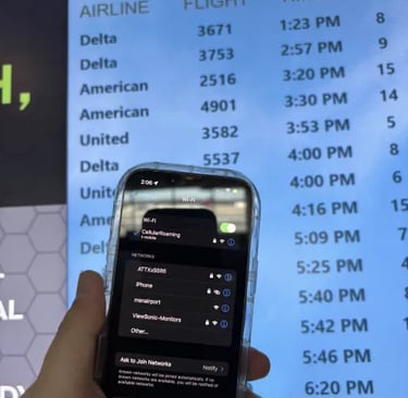 a person holding a cell phone in front of a screen