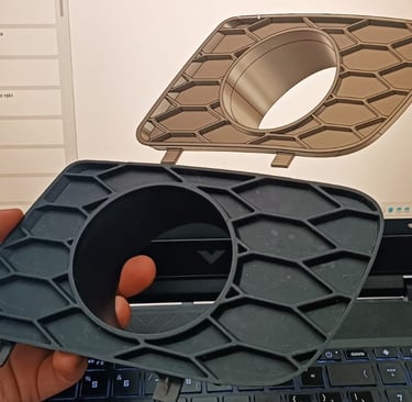 trzyma w ręku prototypowany element samochodu