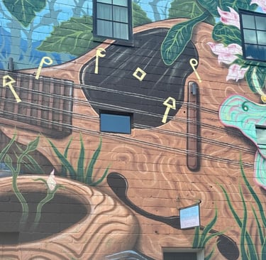 Guitar and luna moth painting on a building representing locksmith for Mars Hill, NC