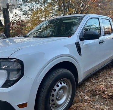 White pickup parked in a wooded residential driveway in Fairview, North Carolina
