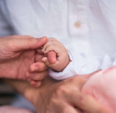 Little child holding the hands of Mother, with father supporting