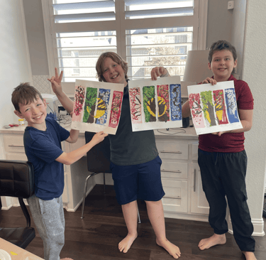 Happy kids proudly showing their colorful tree paintings at Kelley's Neighborhood Art