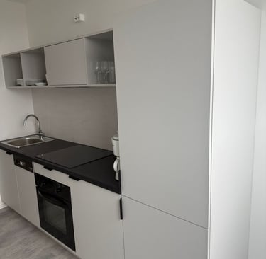 Moderne, minimalistische Einbauküche mit hellen Fronten und schwarzer Arbeitsplatte