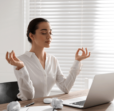a woman sitting at a desk with her hands up and her hands up