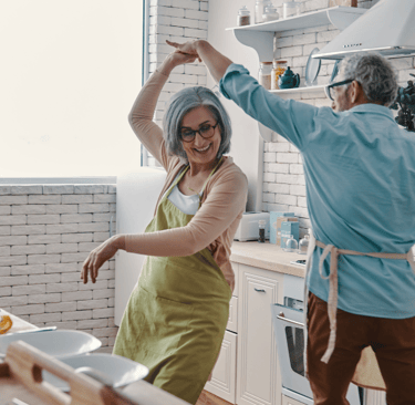 a man and woman dancing in a kitchen