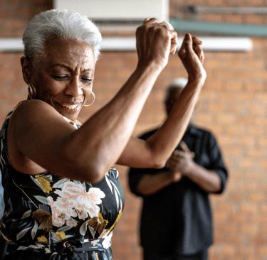 a woman in a floral dress dancing with a man in a suit