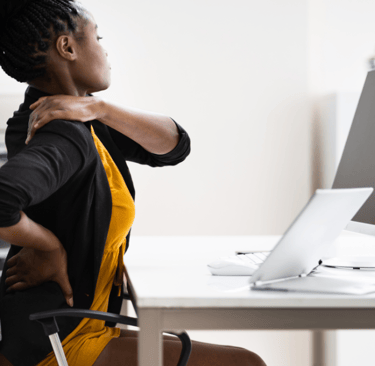 a woman sitting at a desk with a computer monitor and a monitor screen