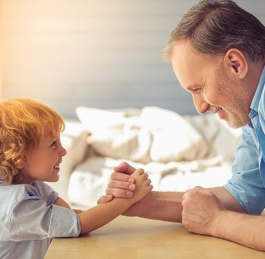 father and son arm wrestling and laughing - language science - who learns better