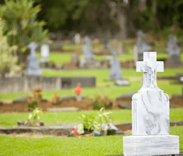 a cross - cut stone memorial cross in a cemetery