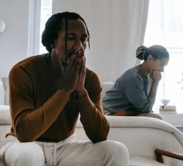 a man and woman sitting on a couch in a living room
