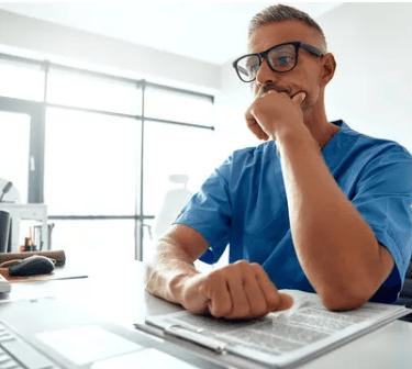 a man sitting at a desk with a keyboard and a computer