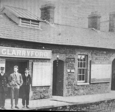 An old black and white picture of Glarryford Train Station. There are three men standing out front. 