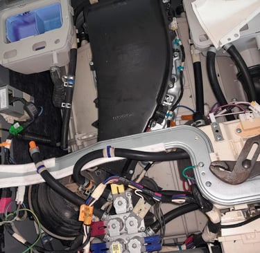 LG washer dryer combo internal view showing heater inspection during DHE error diagnosis – hoses, wi