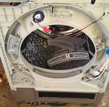 Front panel removed from LG heat pump dryer to inspect internal components due to burnt smell issue