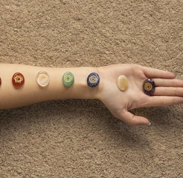 Bras allongé avec pierres de chakras alignées pour un soin énergétique et un rééquilibrage énergétiq