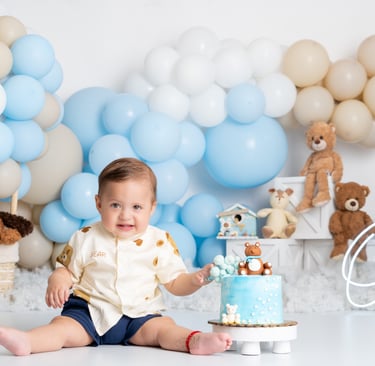 a baby boy in a blue and white cake smash cake