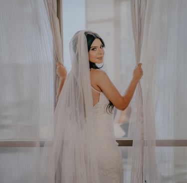 Novia con vestido blanco de espaldas abriendo cortina - Mejor fotógrafo de bodas en Guadalajara, Mx