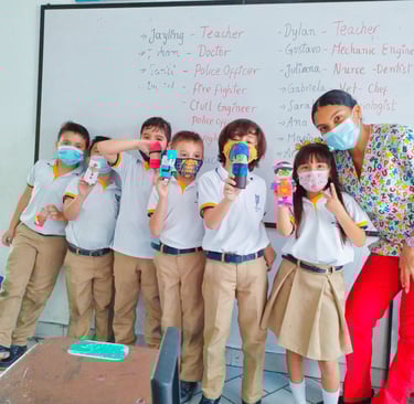 a group of children and the teacher posing for a picture, after finishing a creative task