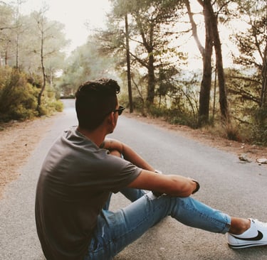 Guy sitting on a road in a forest
