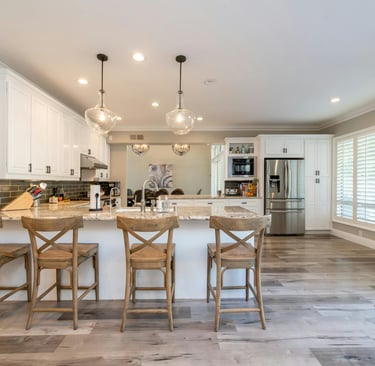 bright open kitchen and dining area with natural light, spotless counters, and welcoming table setti