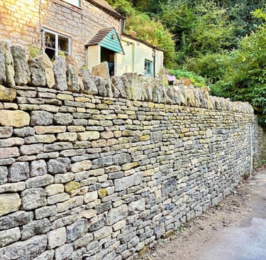A traditional dry stone retaining wall with cock and hen capping