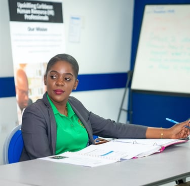 a woman in a green shirt and a white shirt listening intently to a presentation