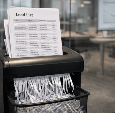Printed lead list being shredded in office paper shredder