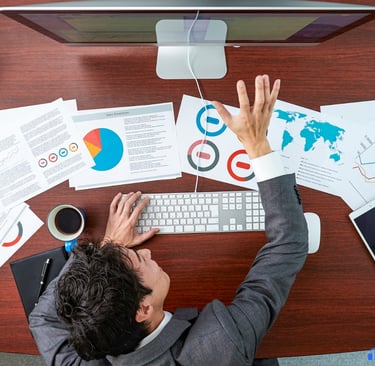Founder infront of a computer with data sheets scattered on the table